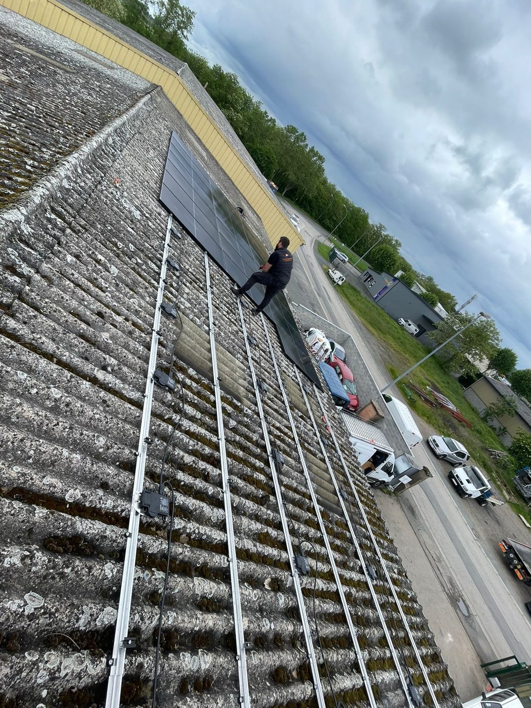 Technicien ENERSY posant des panneaux photovoltaïques sur une toiture industrielle